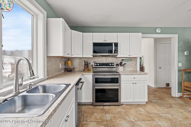 kitchen with sink, appliances with stainless steel finishes, and white cabinetry