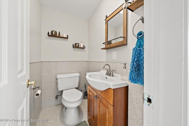 bathroom featuring tile walls, toilet, and vanity