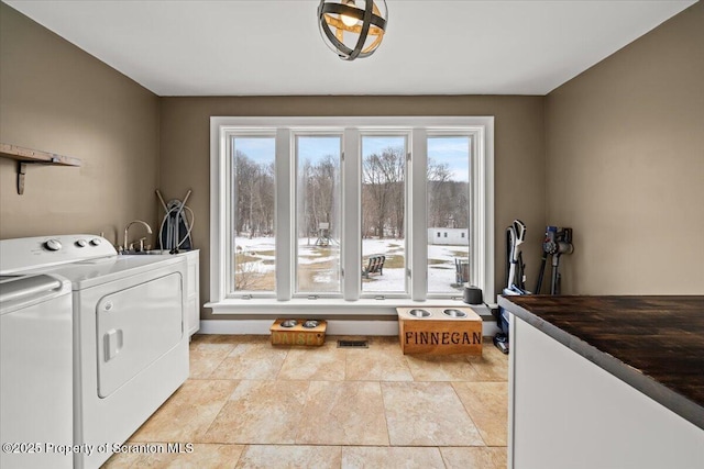 washroom with washing machine and dryer and cabinets