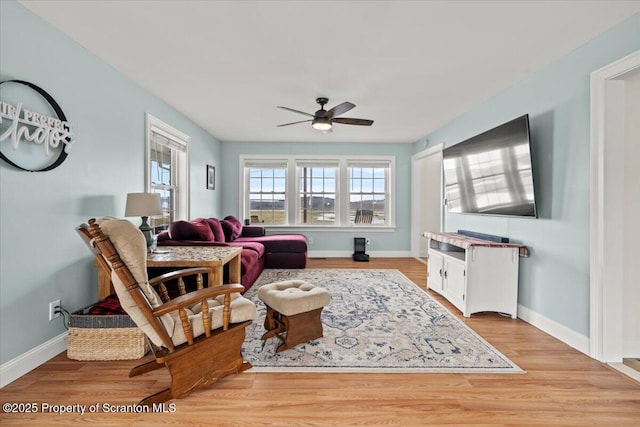 living room featuring a healthy amount of sunlight, ceiling fan, and light hardwood / wood-style floors