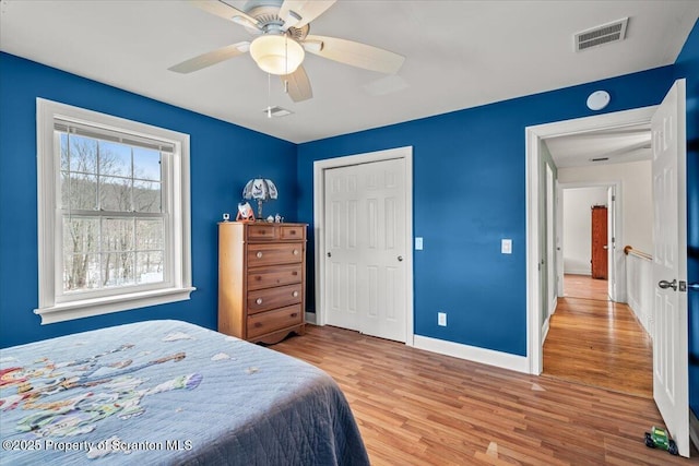 bedroom with a closet, ceiling fan, and light hardwood / wood-style flooring