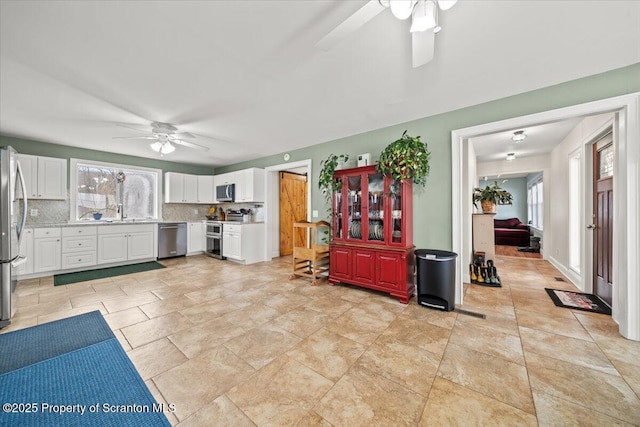 kitchen featuring white cabinetry, tasteful backsplash, stainless steel appliances, and plenty of natural light