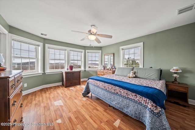 bedroom with multiple windows, ceiling fan, and light hardwood / wood-style floors