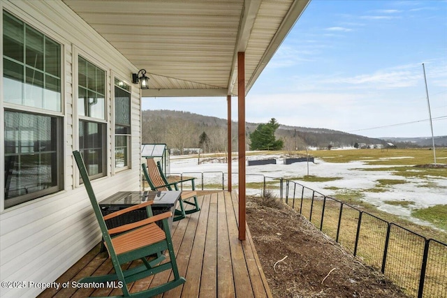 snow covered deck with a mountain view