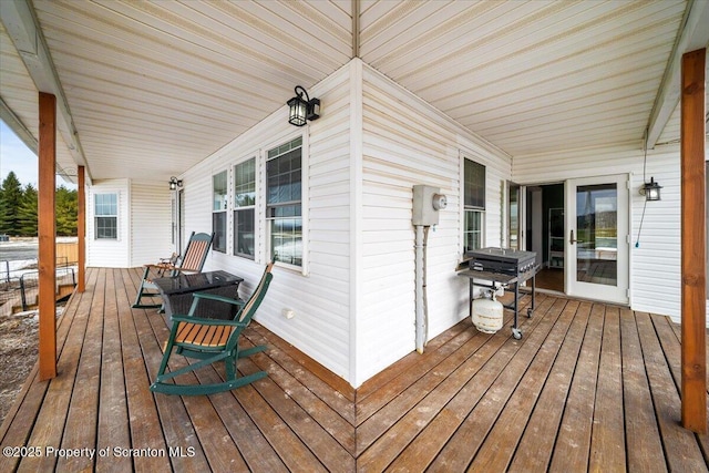 wooden terrace featuring covered porch and grilling area