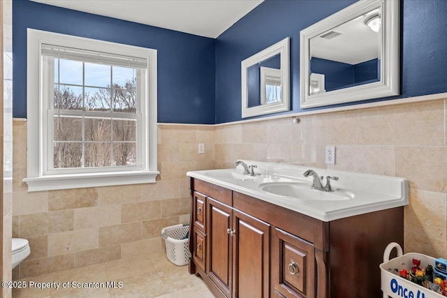 bathroom featuring tile walls, vanity, tile patterned flooring, and toilet