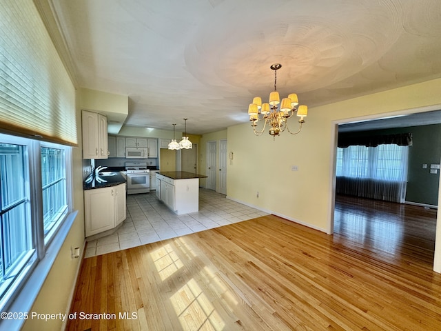 13 Forest Glen Dr, Scranton, PA 18504 - kitchen featuring white appliances, a chandelier, dark countertops, light wood-style flooring, and a kitchen island