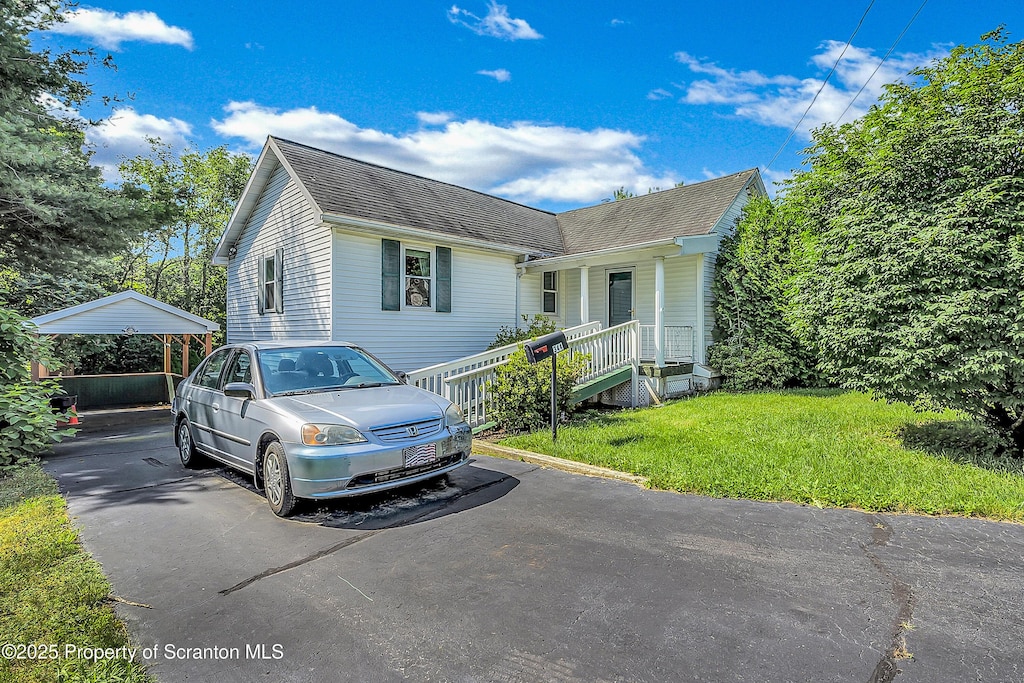344 2nd St, Eynon, PA 18403 - view of front facade featuring roof with shingles, a front lawn, a detached carport, and a porch