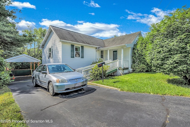 344 2nd St, Eynon, PA 18403 - view of front facade featuring roof with shingles, a front lawn, a detached carport, and a porch