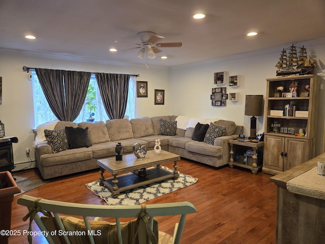 living room with ceiling fan, crown molding, dark wood-type flooring, and a baseboard heating unit