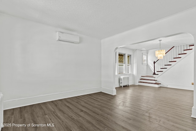 37 Goeringer Ave, Hanover Twp, PA 18706 - unfurnished room with wood finished floors, arched walkways, radiator, and a wall mounted AC