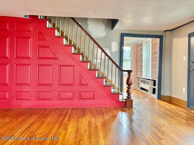 foyer entrance featuring radiator heating unit and hardwood / wood-style floors