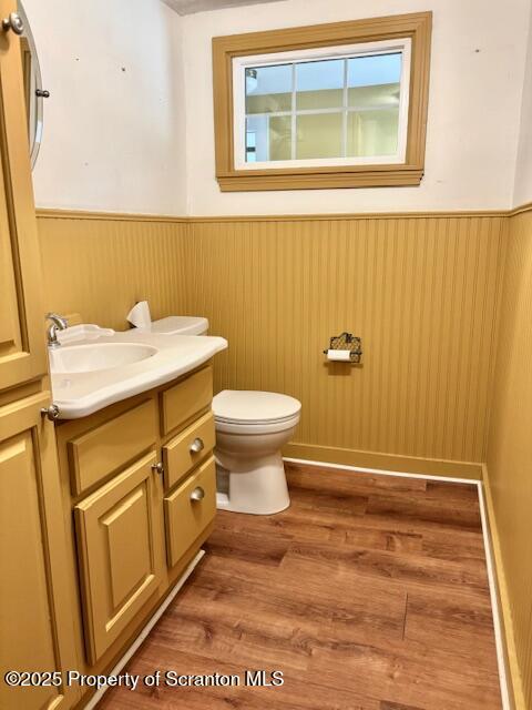 bathroom with wood-type flooring, toilet, and vanity