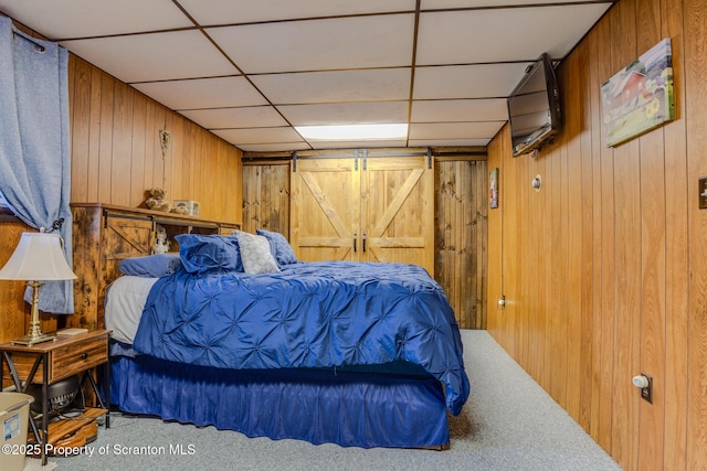 125 Frances Ln, Greentown, PA 18426 - bedroom with wooden walls, carpet flooring, a barn door, and a drop ceiling