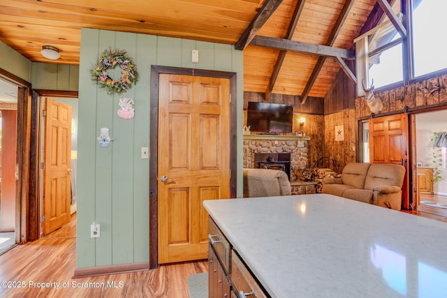 125 Frances Ln, Greentown, PA 18426 - kitchen featuring wood walls, light wood-type flooring, beam ceiling, wood ceiling, and a fireplace