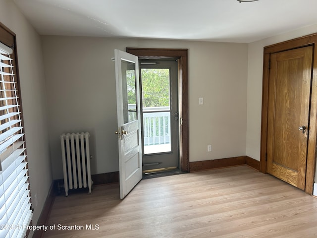 doorway to outside featuring radiator heating unit and light hardwood / wood-style floors