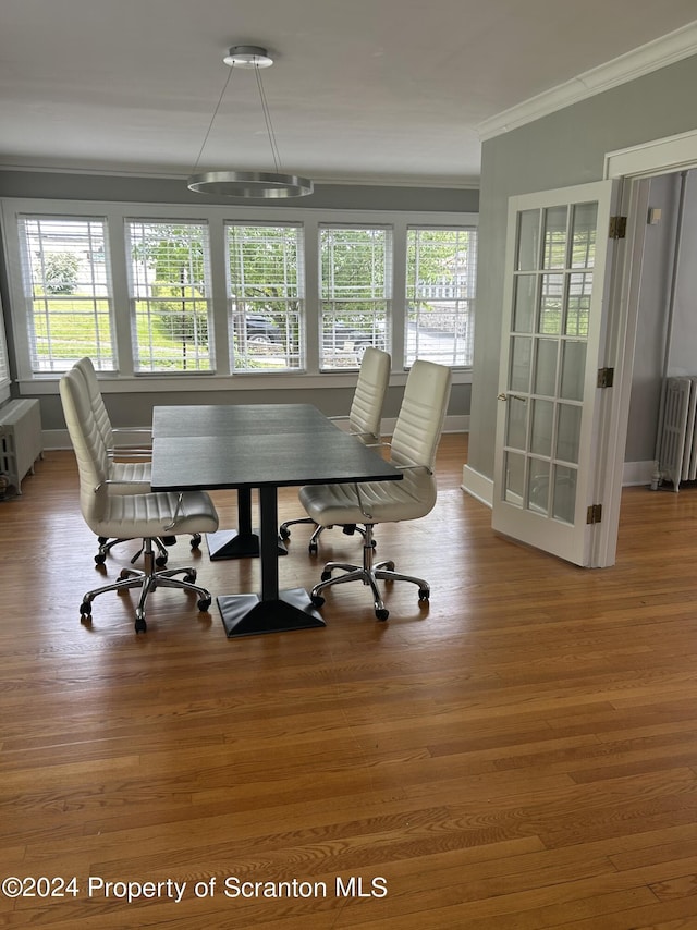 dining room with hardwood / wood-style flooring, radiator heating unit, and ornamental molding