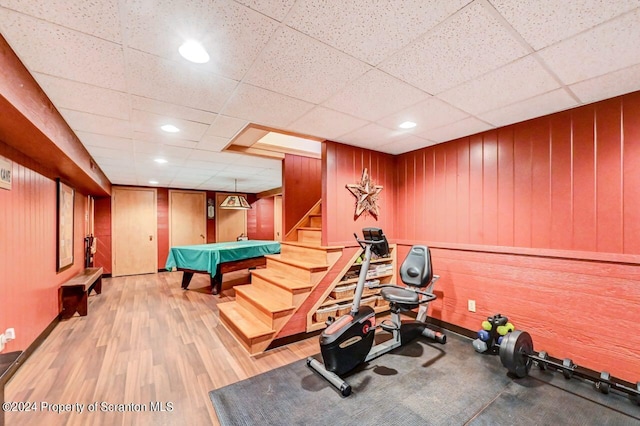 exercise area with a paneled ceiling, light hardwood / wood-style flooring, and billiards