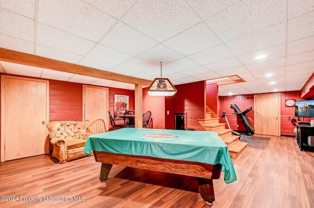 rec room featuring a paneled ceiling, light hardwood / wood-style flooring, wooden walls, and billiards