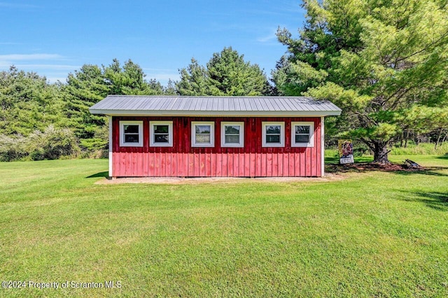 view of outbuilding featuring a lawn