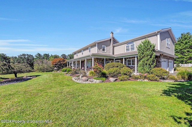 back of property with a garage and a yard