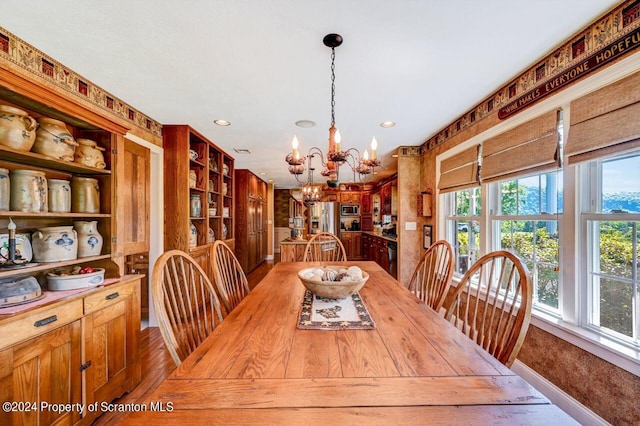 dining space featuring hardwood / wood-style floors and a notable chandelier