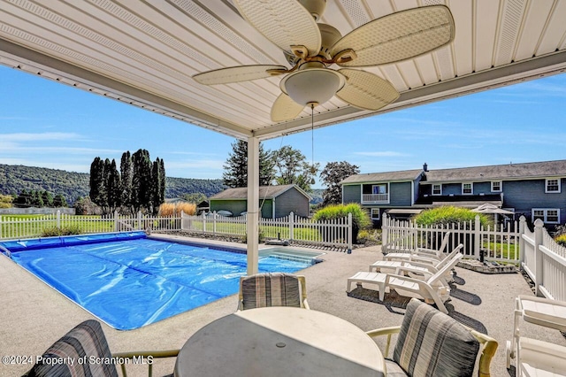 view of pool featuring a mountain view, a patio, and ceiling fan