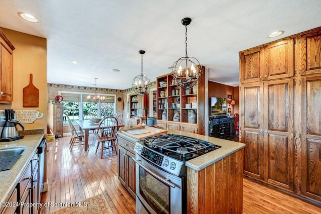 kitchen with pendant lighting, a center island, sink, light hardwood / wood-style floors, and stainless steel appliances