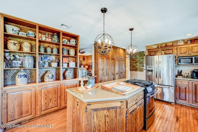 kitchen with a center island, an inviting chandelier, light hardwood / wood-style floors, pendant lighting, and appliances with stainless steel finishes