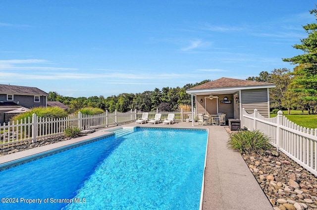 view of pool with a patio, ceiling fan, and an outdoor structure