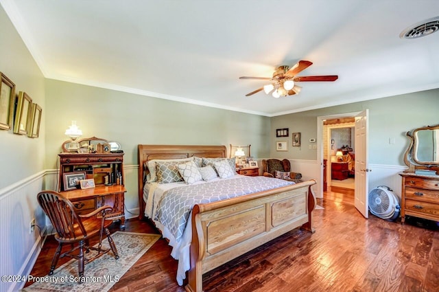 bedroom with ceiling fan, dark hardwood / wood-style floors, and ornamental molding