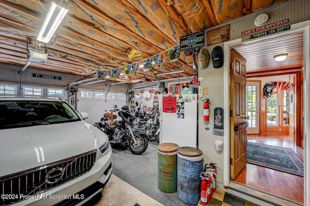 garage with white fridge and a garage door opener