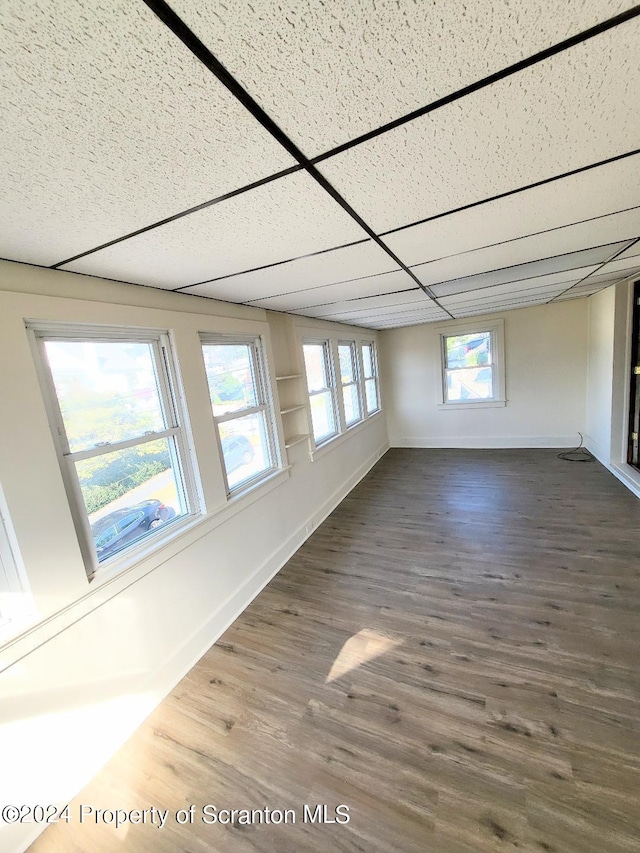 unfurnished room featuring a drop ceiling and dark hardwood / wood-style floors