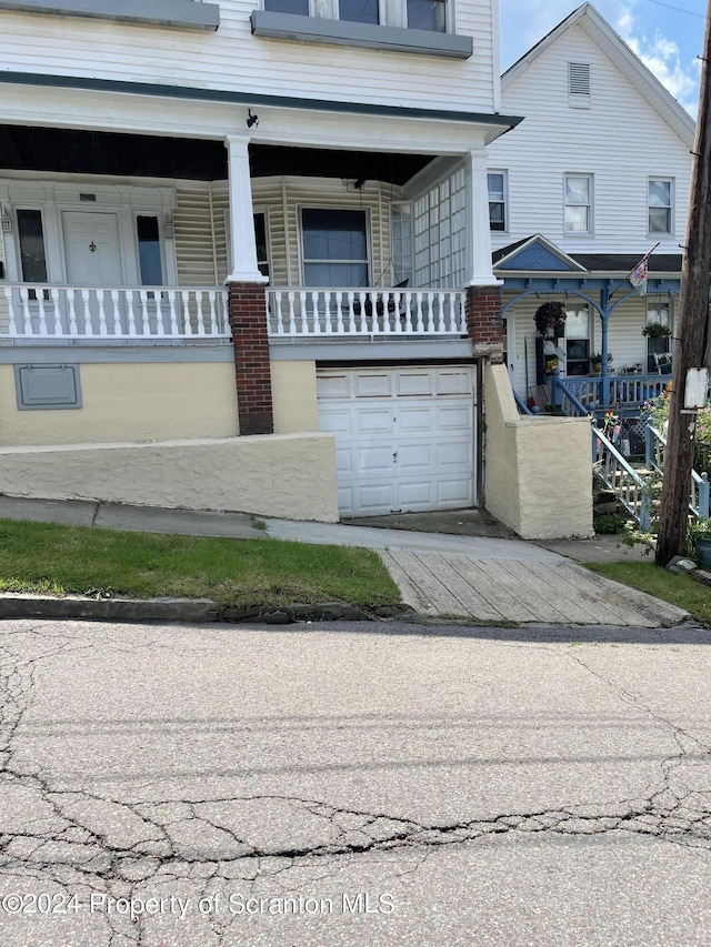 view of front of property featuring covered porch and a garage