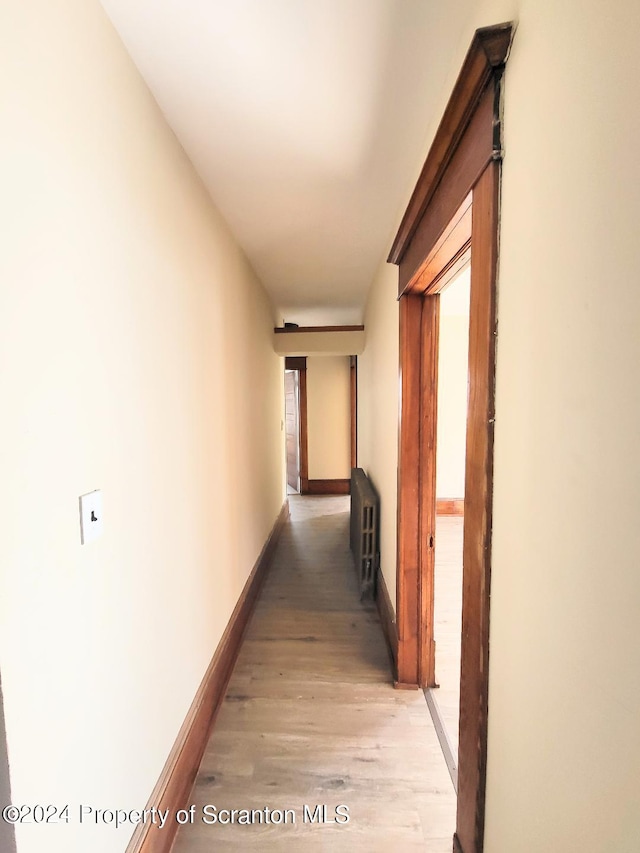 corridor with radiator heating unit and light wood-type flooring