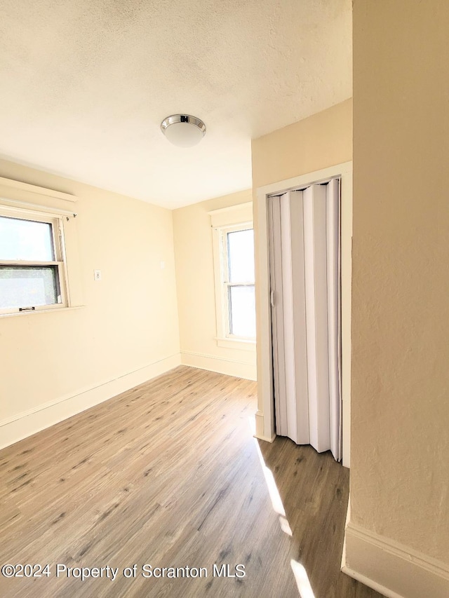 spare room with wood-type flooring and a textured ceiling