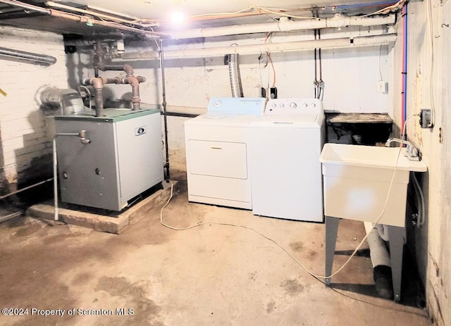 laundry area with independent washer and dryer and sink