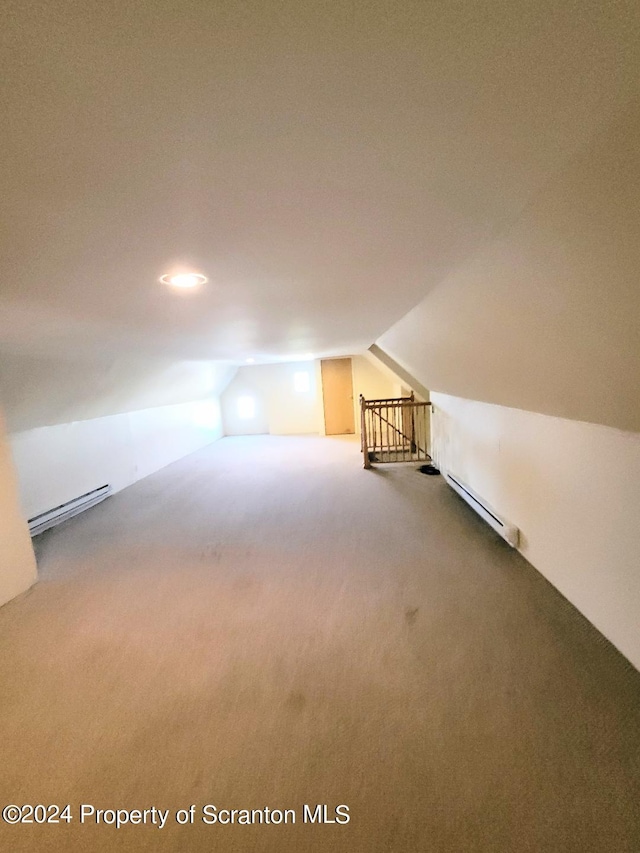 additional living space with carpet floors, a baseboard radiator, and lofted ceiling