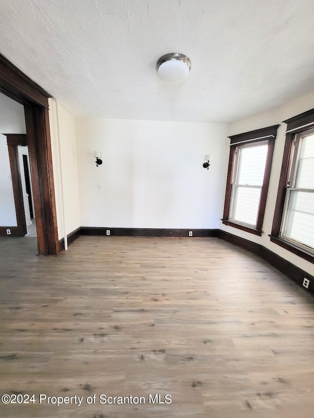 spare room featuring hardwood / wood-style floors and a textured ceiling