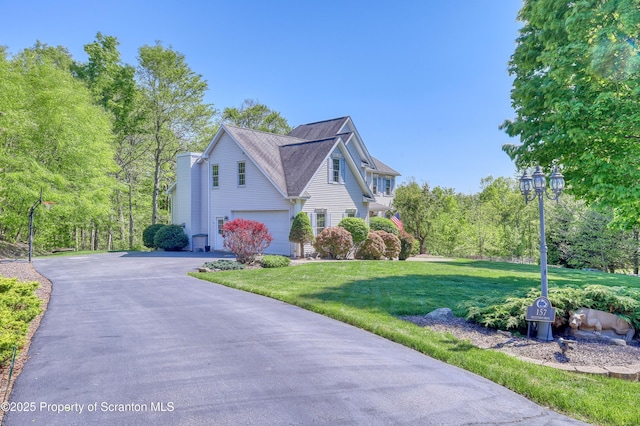 157 Mcesther Dr Unit L 31, Covington Twp, PA 18424 - view of side of property with asphalt driveway, a garage, and a lawn