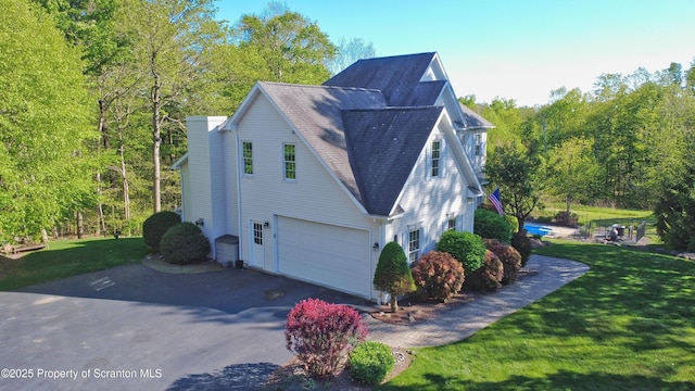 157 Mcesther Dr Unit L 31, Covington Twp, PA 18424 - view of home's exterior featuring asphalt driveway, a garage, a shingled roof, and a lawn
