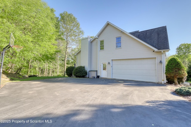 157 Mcesther Dr Unit L 31, Covington Twp, PA 18424 - view of side of property with concrete driveway, a shingled roof, and a garage