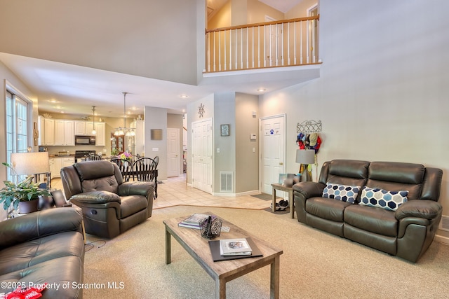 157 Mcesther Dr Unit L 31, Covington Twp, PA 18424 - living area with a high ceiling, light carpet, a chandelier, and light tile patterned flooring
