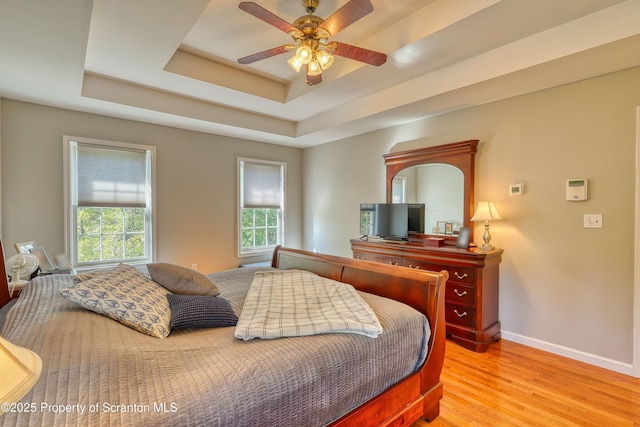 157 Mcesther Dr Unit L 31, Covington Twp, PA 18424 - bedroom featuring light wood-style floors, a tray ceiling, and ceiling fan