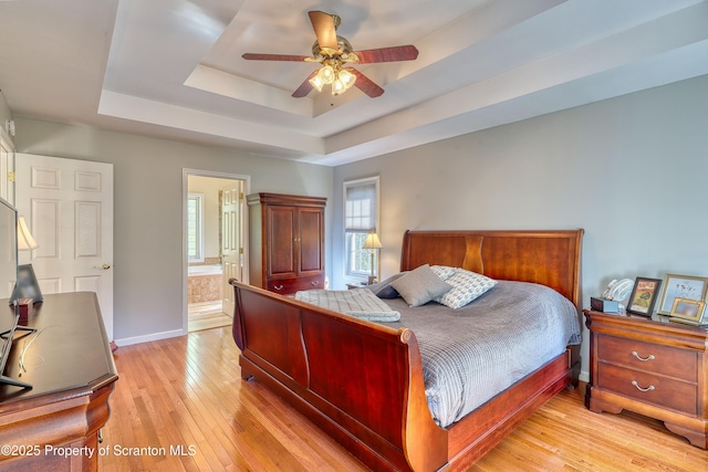 157 Mcesther Dr Unit L 31, Covington Twp, PA 18424 - bedroom with a raised ceiling, light wood finished floors, ensuite bath, and a ceiling fan