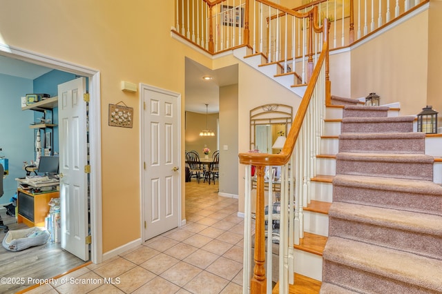 157 Mcesther Dr Unit L 31, Covington Twp, PA 18424 - staircase with tile patterned flooring, a high ceiling, and a chandelier
