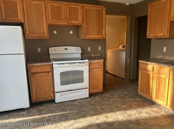 kitchen featuring washer and clothes dryer and white appliances