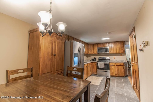 kitchen featuring decorative light fixtures, light tile patterned floors, stainless steel appliances, and a chandelier