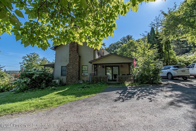 view of front of property featuring covered porch and a front yard