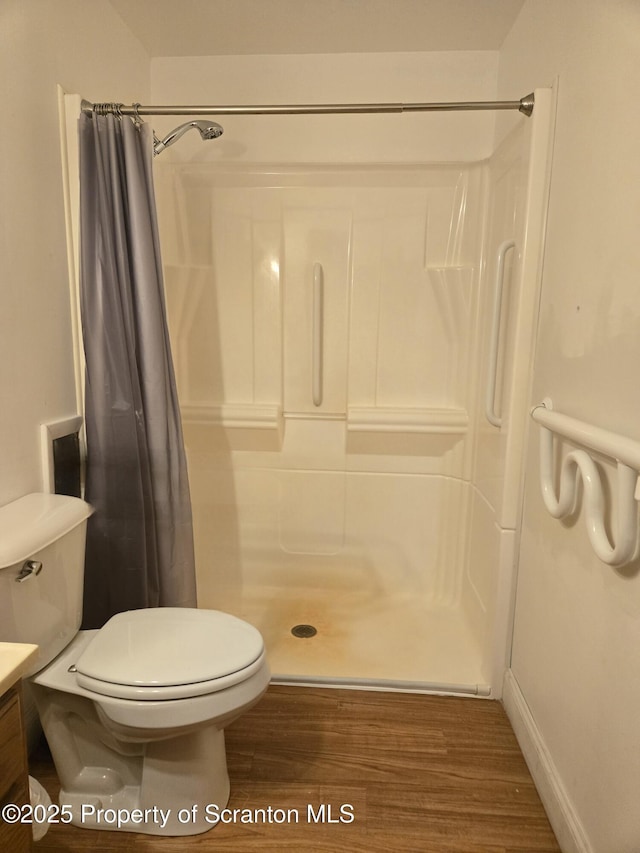 full bath with wood finished floors, curtained shower, vanity, and toilet